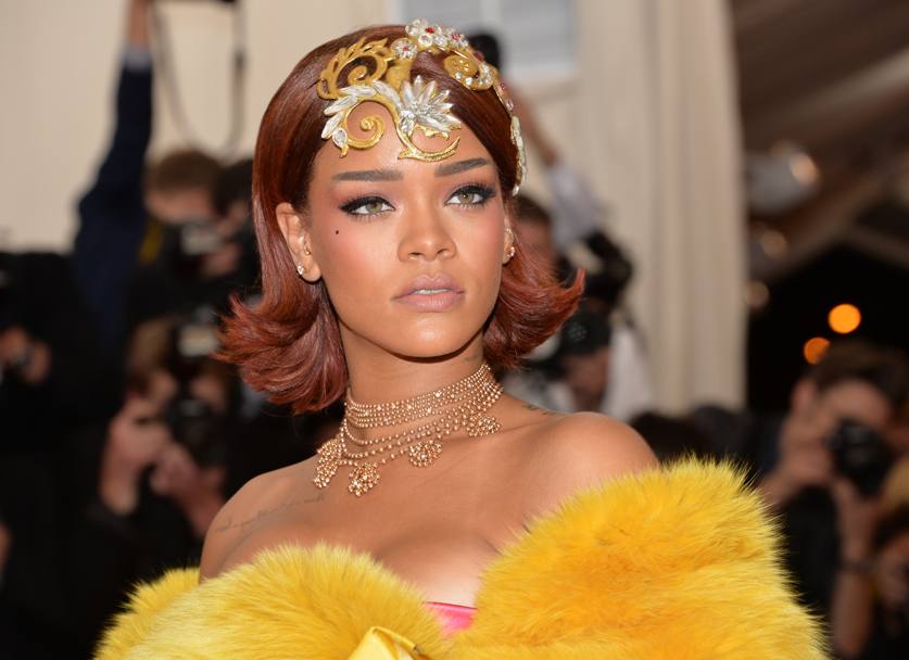 Rihanna sceglie il giallo: una mega stola pelosa. Sul red carpet fa effetto frittata. Sotto, niente. O quasi